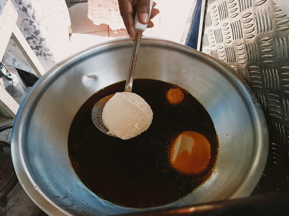 Fritters frying in a vat of palm oil
