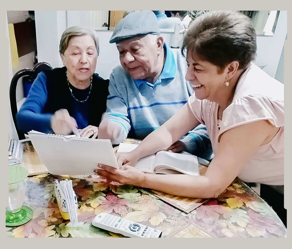 Pati reviewing the calendar with her parents, which is where she keeps track of their medications and upcoming appointments