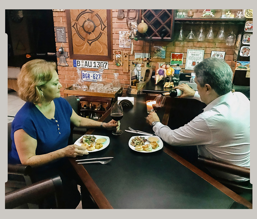 Sharing a glass of wine and snacks with husband at home