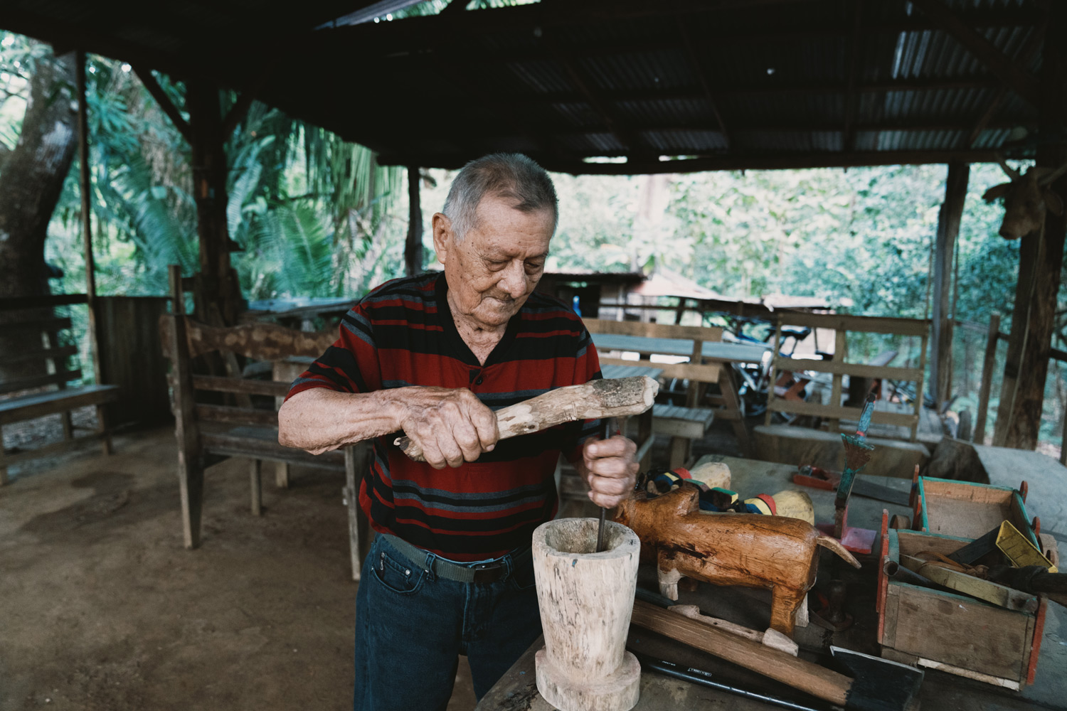 A carpenter and farmer for much of his life, demonstrates his wood working skills