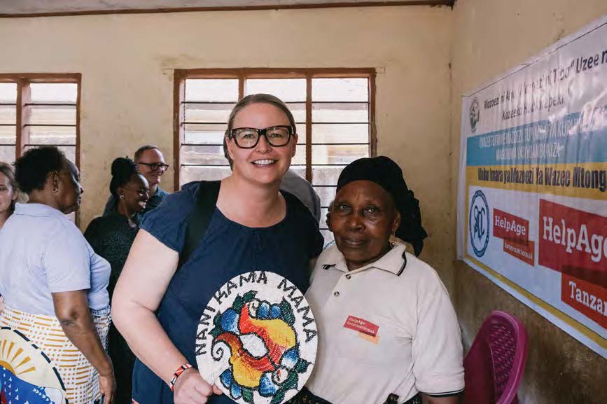 With Fatuma Rajabu Saidi, Chairperson of the Mtonga Active Aging Club, who also serves as an Older People Monitoring and a Home- Based Care Provider. The Swahili saying on the fan is “nani kama mama,” meaning “who is like a mother.